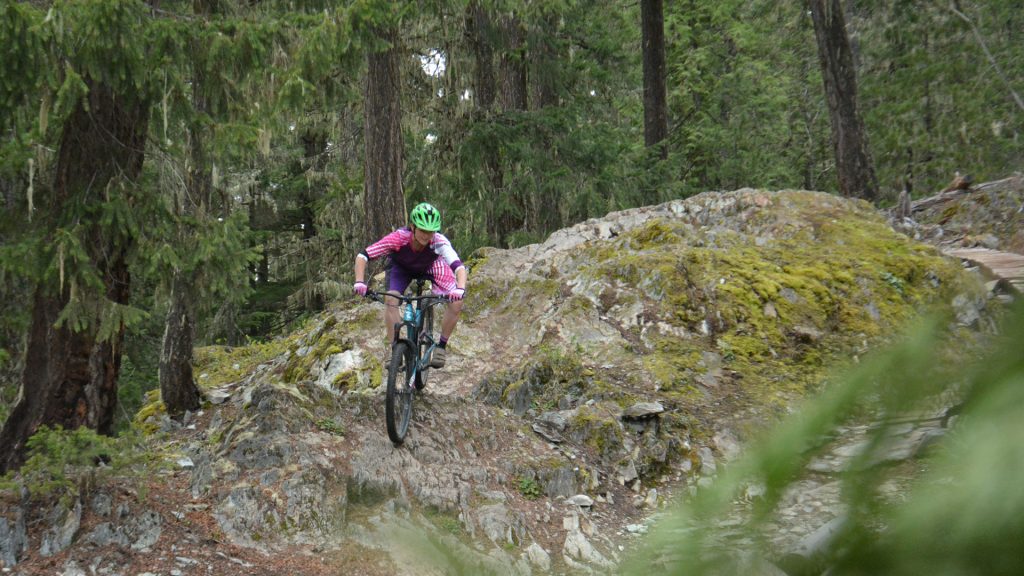 Mountain biker riding down a rock face in Lost Lake Park in Whistler, BC