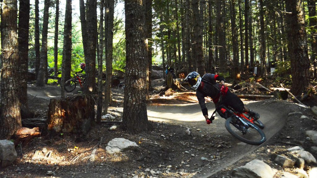 Mountain bikers descending on a Whistler Bike Park trail. 